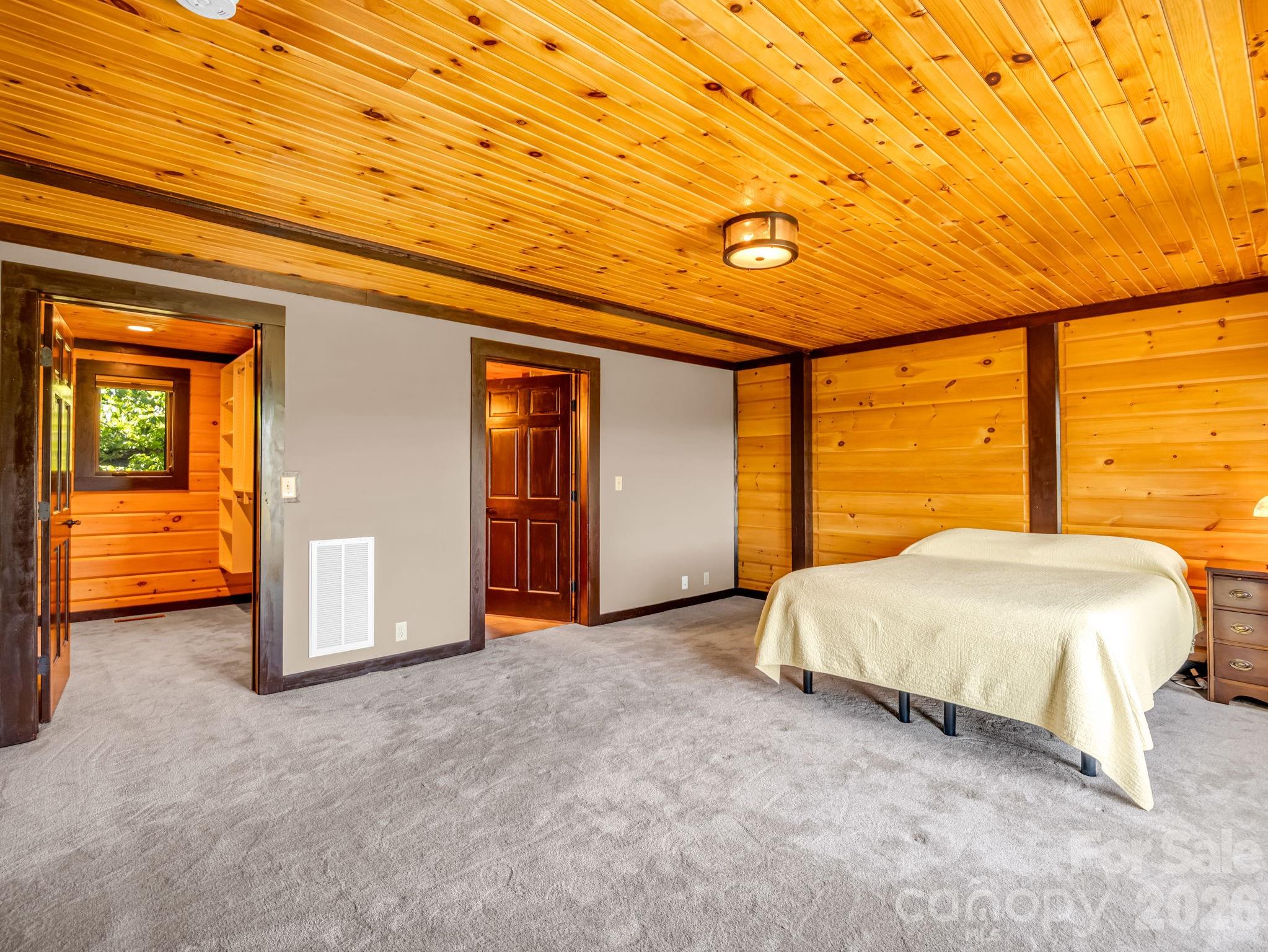 590 Boulder Ridge Lake Lure, NC 28746 - Photo 22 of 48 a spacious bedroom with a large bed and a window