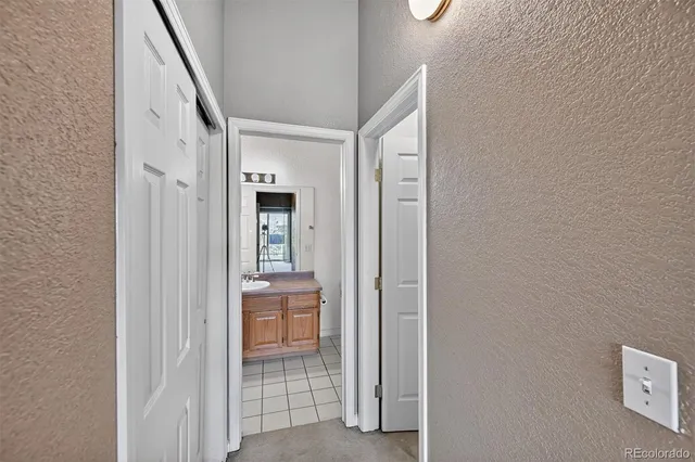 a view of a hallway with wooden floor and a bathroom