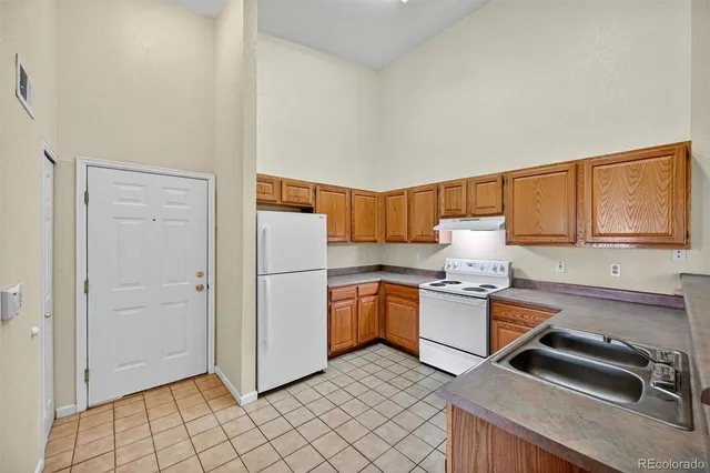 a kitchen with stainless steel appliances granite countertop a refrigerator sink and stove