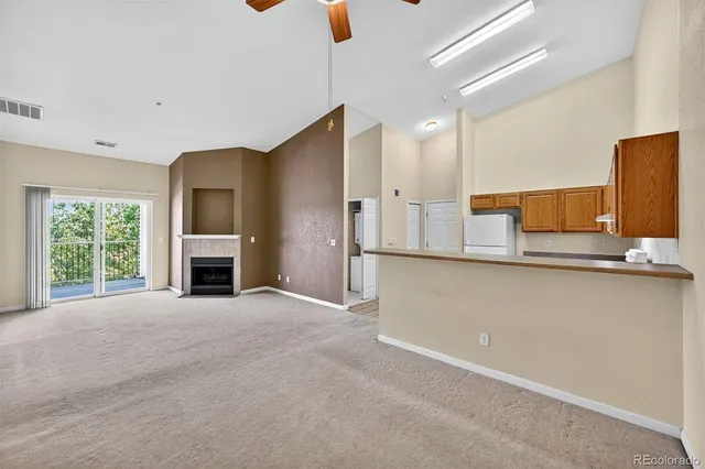 a view of an empty room with a fireplace and a window
