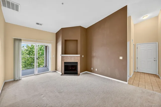 a view of empty room with a fireplace and a window