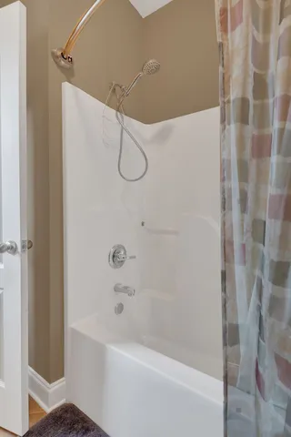 a view of a yard in front of a brick house with plants and large windows