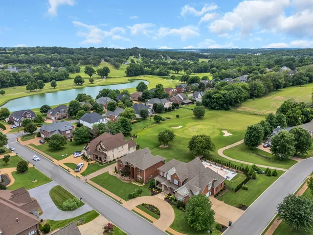 an aerial view of residential houses with outdoor space and river