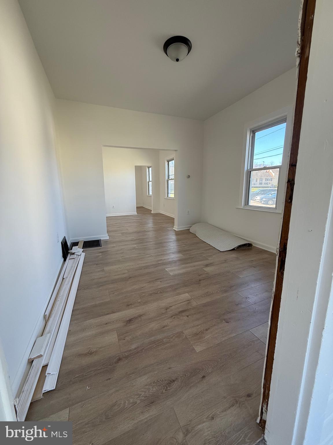 239 Midland Brooklyn, MD 21225 - Photo 2 of 13 wooden floor in an empty room with a window