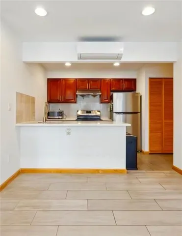 a kitchen with stainless steel appliances a refrigerator and a stove top oven
