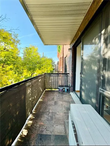 a view of a balcony with floor to ceiling windows and wooden floor