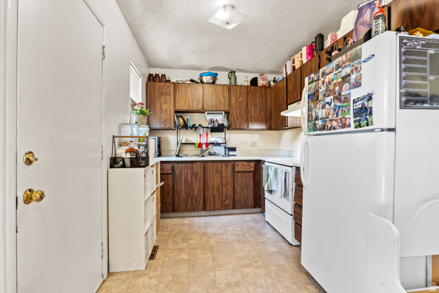2327 880 North Provo, UT 84601 - Photo 2 of 15 Kitchen featuring wood-finish cabinetry, white countertops, and vinyl flooring