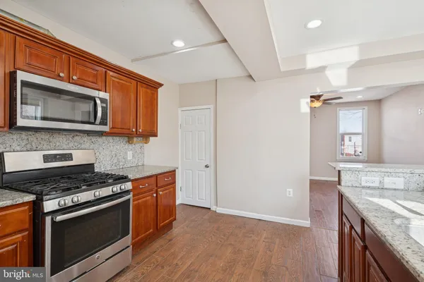 a kitchen with granite countertop wooden cabinets and stainless steel appliances