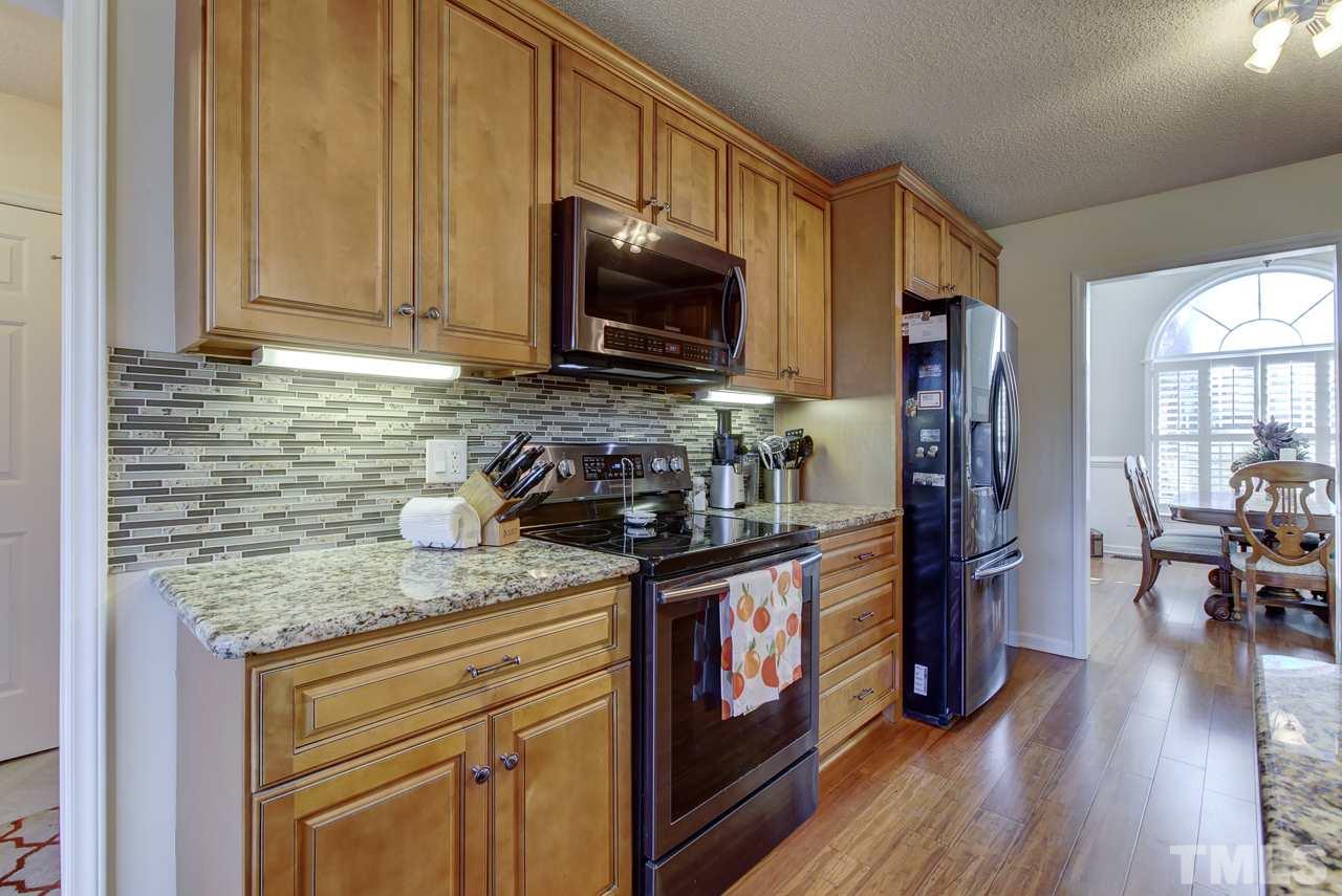 247 Cross Ridge Drive Willow Spring, NC 27592 - Photo 9 of 25 a kitchen with stainless steel appliances granite countertop a stove refrigerator sink and cabinets