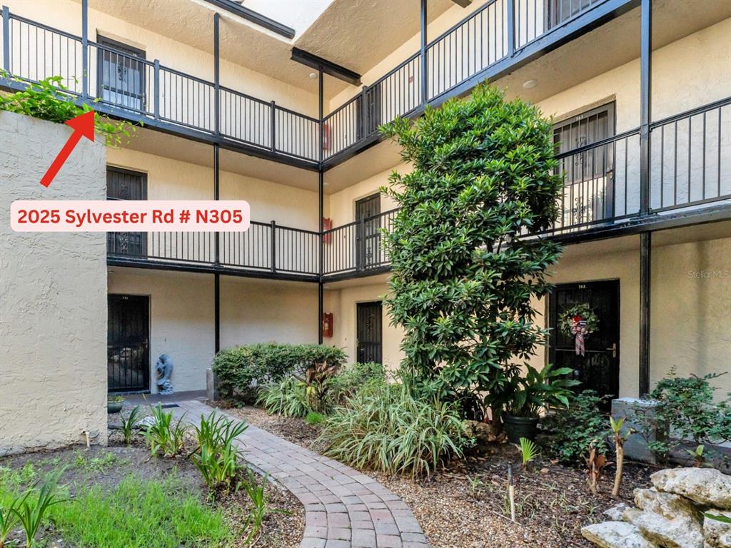 2025 Sylvester Road, Unit N305 Lakeland, FL 33803 - Photo 5 of 34 a multi story building with potted plants in front of it