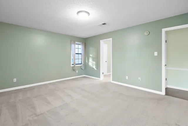 an empty room with windows and closet