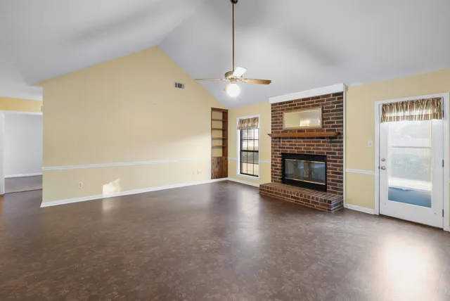 a view of a livingroom with a fireplace and window