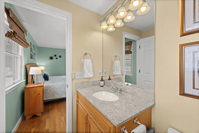 a en suite bathroom with a granite countertop sink and a mirror
