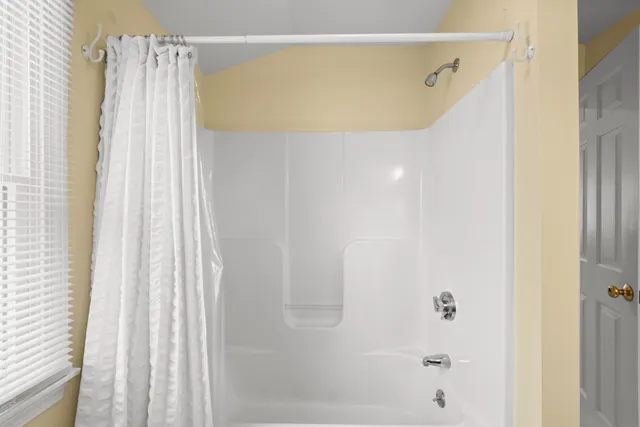 a bathroom with a shower curtain and a window