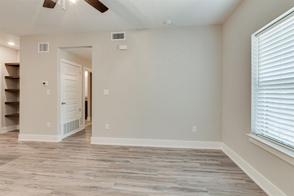 115 West Jones Street, Unit 201 Krum, TX 76249 - Photo 2 of 15 a view of an empty room with window and wooden floor