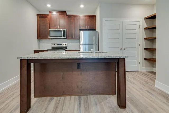 a kitchen with stainless steel appliances granite countertop a sink stove and refrigerator