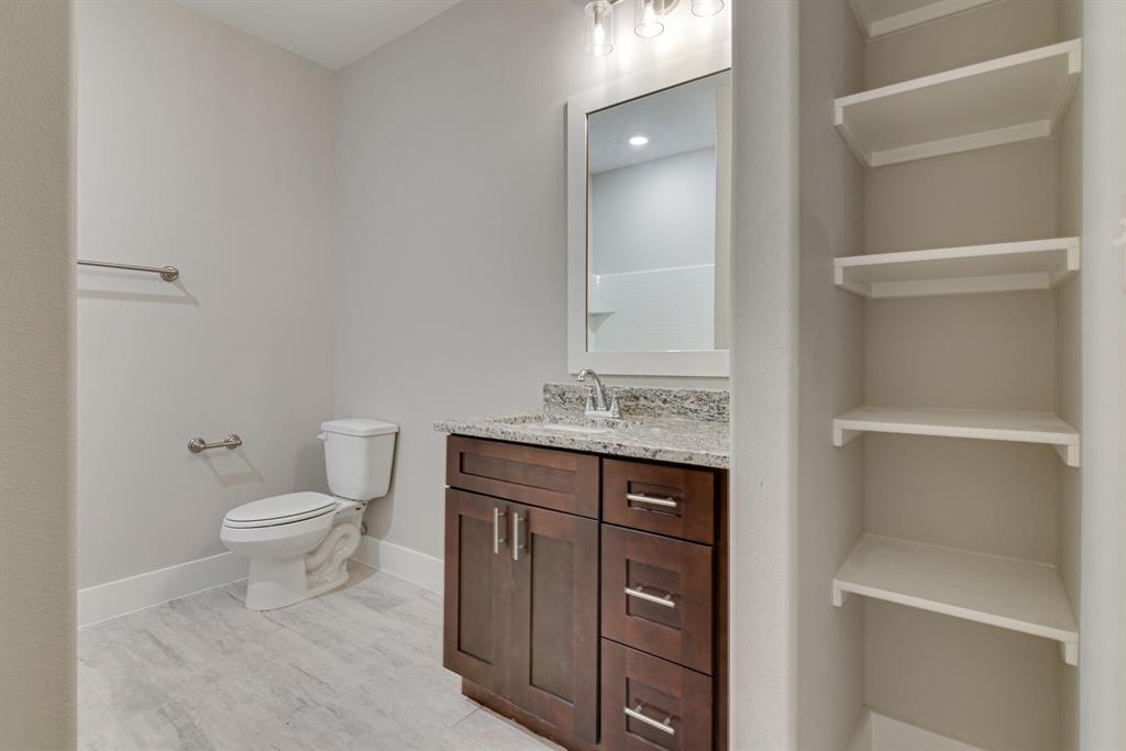 115 West Jones Street, Unit 201 Krum, TX 76249 - Photo 10 of 15 a bathroom with a toilet a sink and vanity