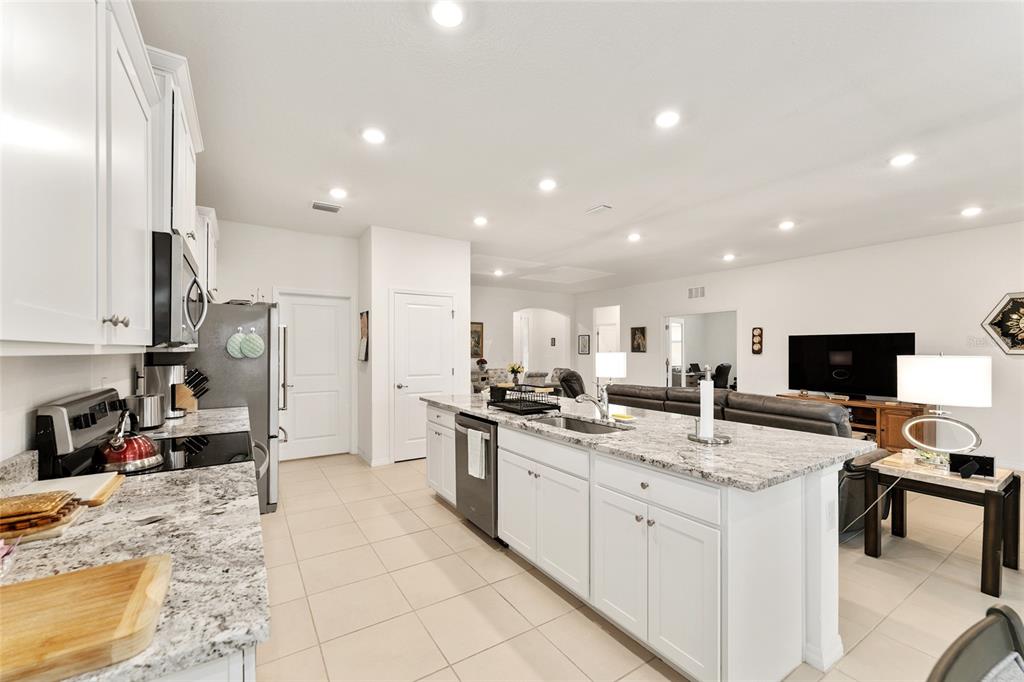 6175 Southwest 88th Loop Ocala, FL 34476 - Photo 14 of 56 a kitchen with stainless steel appliances granite countertop a sink refrigerator and cabinets