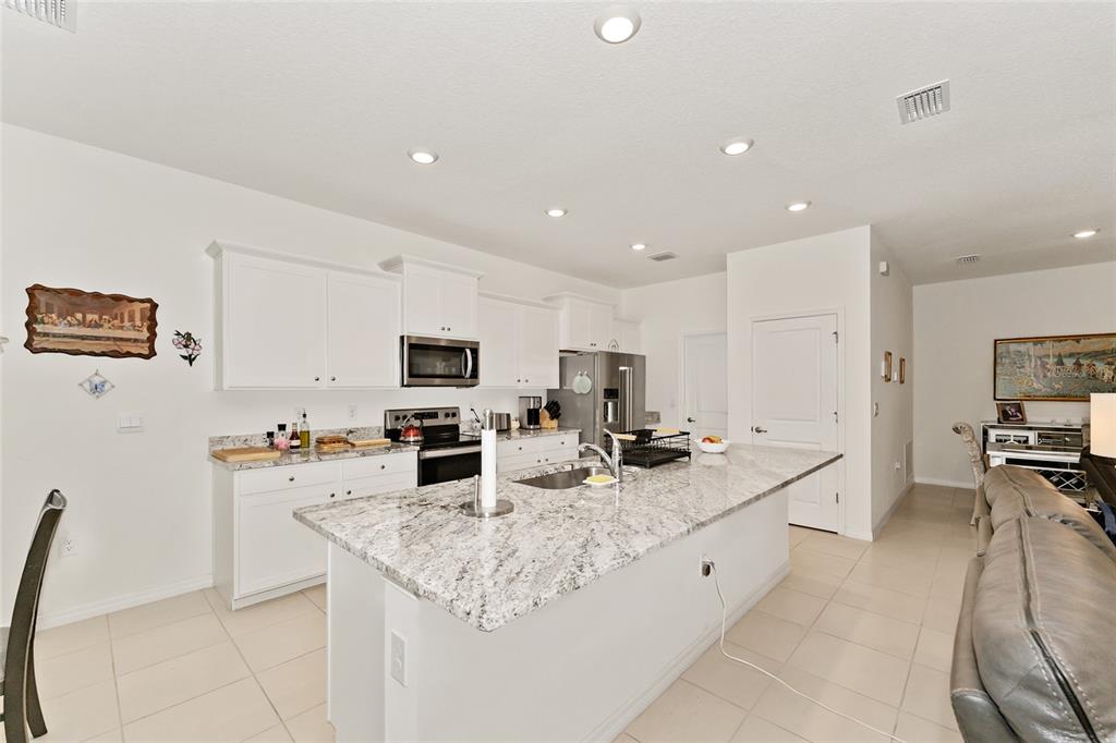 6175 Southwest 88th Loop Ocala, FL 34476 - Photo 16 of 56 a kitchen with stainless steel appliances granite countertop a sink and cabinets