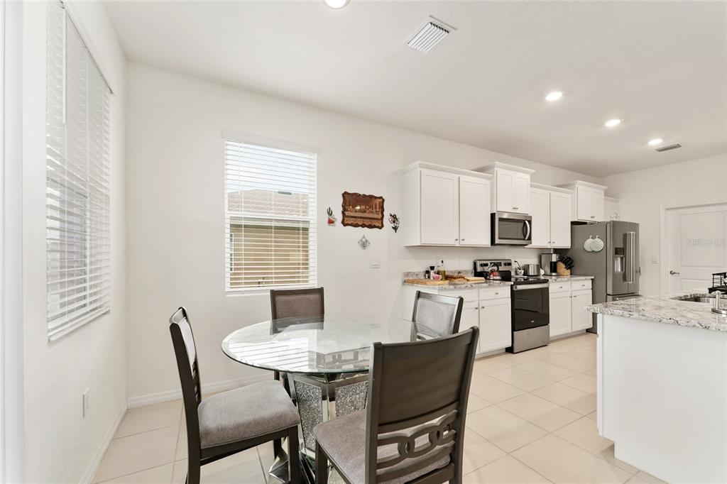 6175 Southwest 88th Loop Ocala, FL 34476 - Photo 21 of 56 a kitchen with stainless steel appliances kitchen island granite countertop a dining table and chairs