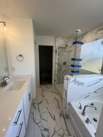 a bathroom with a tub sink and shower