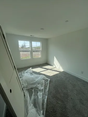 a bed sitting in a bedroom next to a window