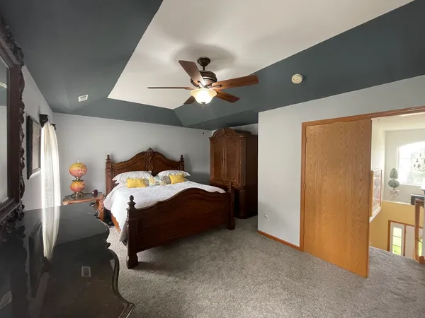 a bedroom with a bed and a ceiling fan