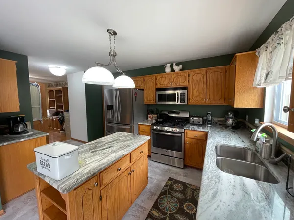 a kitchen with stainless steel appliances granite countertop sink stove and refrigerator