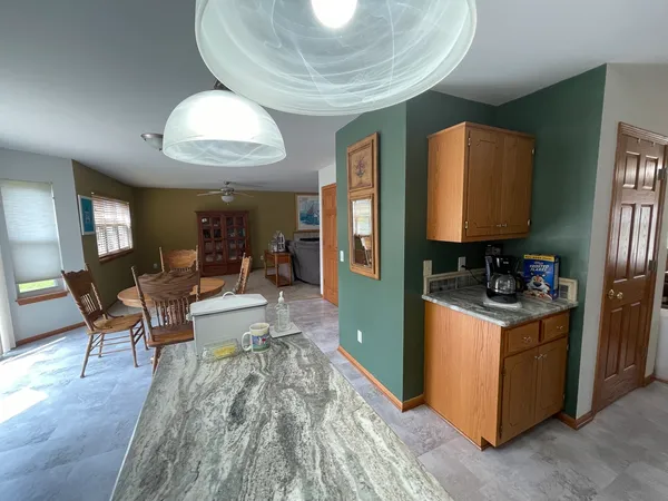 a kitchen with stainless steel appliances granite countertop a stove oven and a dining table with wooden floor