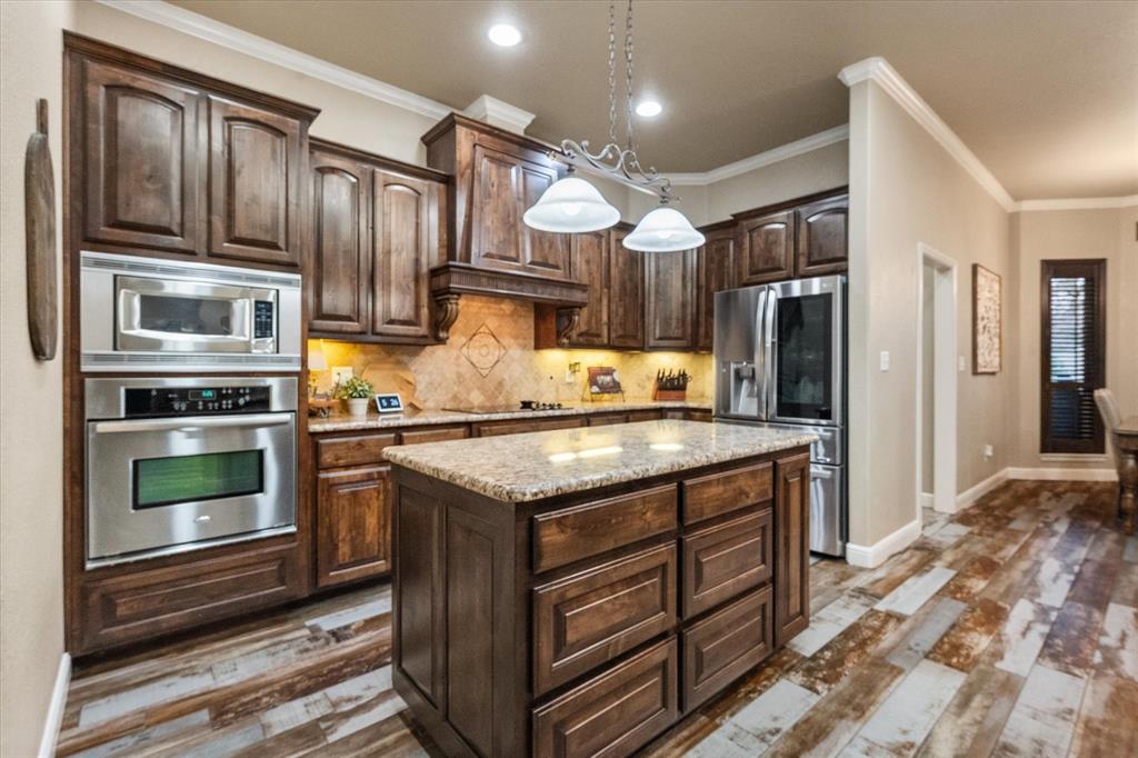 3715 Lonesome Creek Road Granbury, TX 76049 - Photo 16 of 40 a kitchen with stainless steel appliances granite countertop a stove and a refrigerator