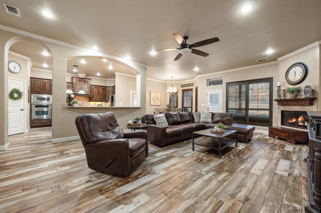 3715 Lonesome Creek Road Granbury, TX 76049 - Photo 20 of 40 a living room with furniture kitchen view and a wooden floor