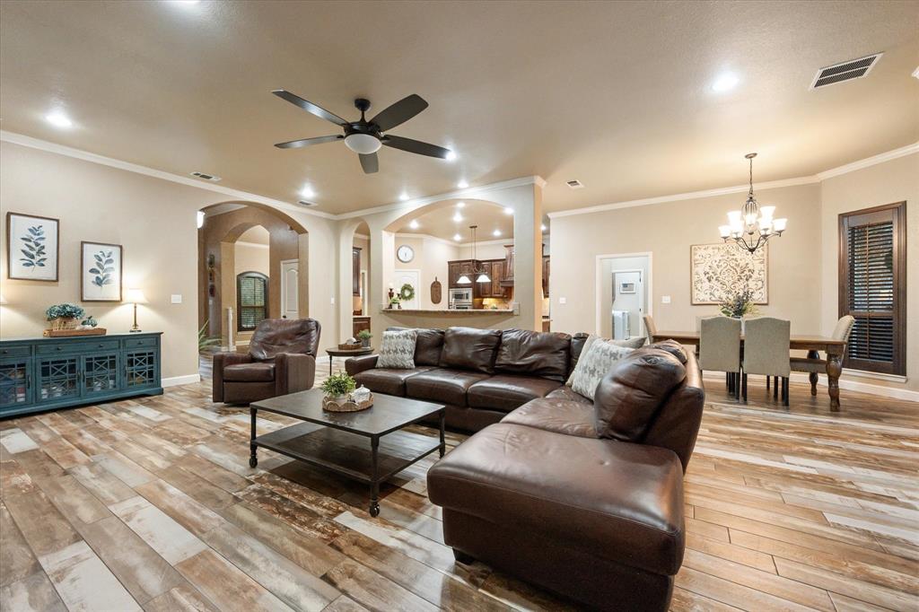 3715 Lonesome Creek Road Granbury, TX 76049 - Photo 21 of 40 a living room with furniture a chandelier and a wooden floor