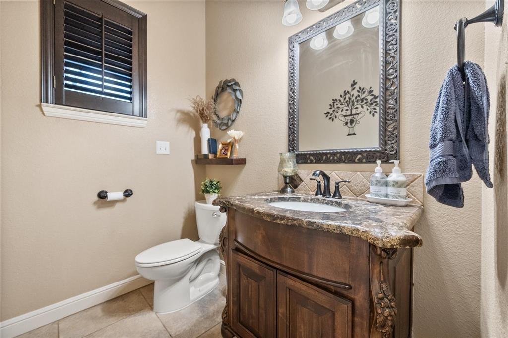 3715 Lonesome Creek Road Granbury, TX 76049 - Photo 31 of 40 a bathroom with a granite countertop sink toilet and mirror