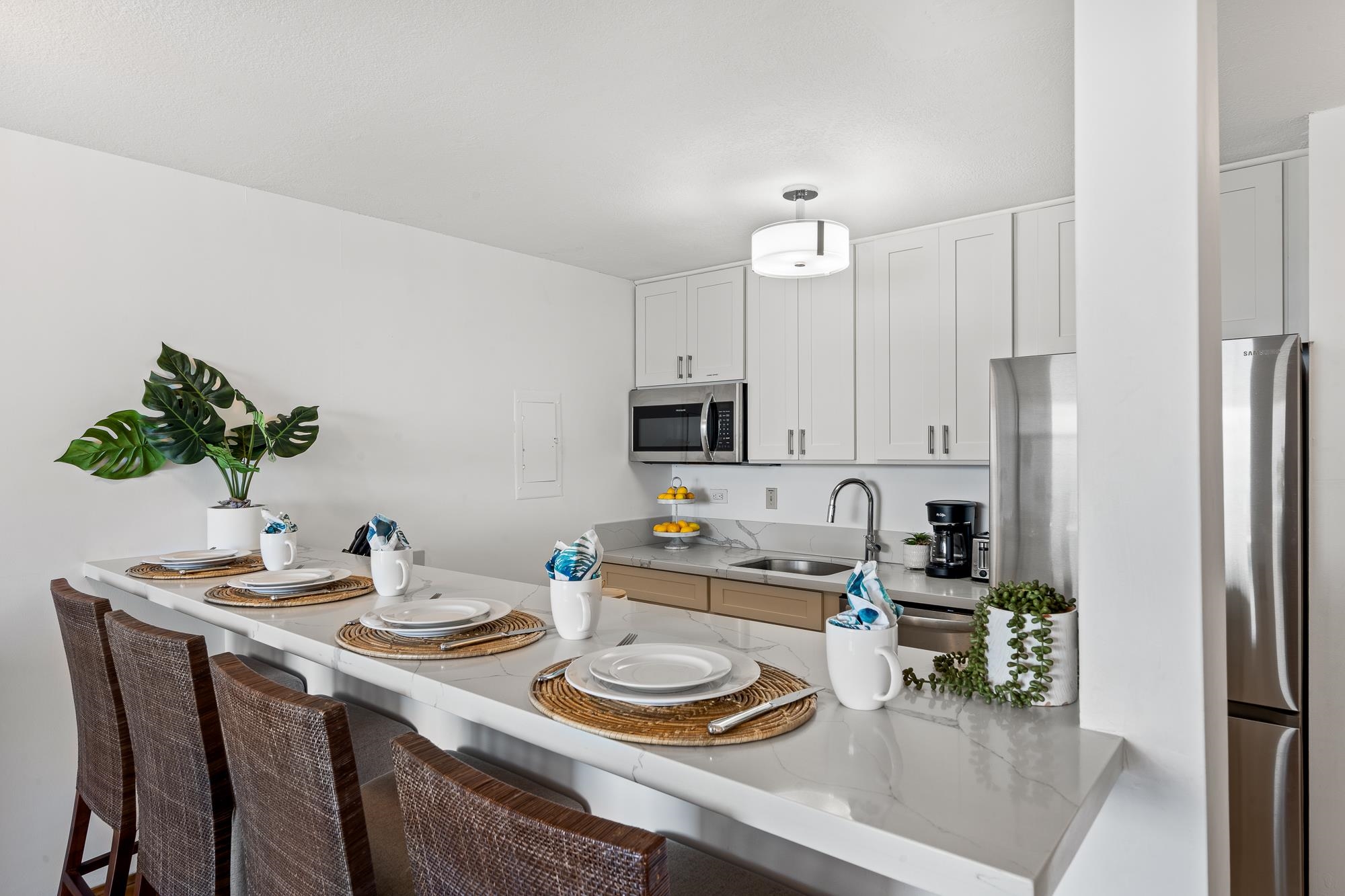4471 Lower Honoapiilani Road, Unit 203 Lahaina, HI 96761 - Photo 12 of 40 a kitchen with sink refrigerator and dining table