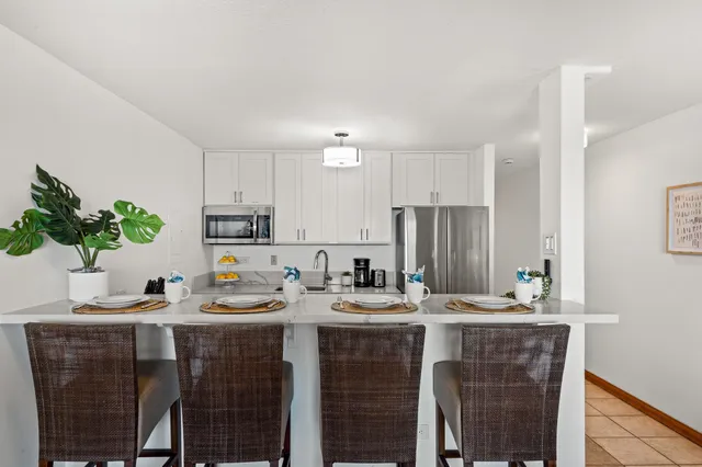 a kitchen with kitchen island granite countertop a sink cabinets and stainless steel appliances