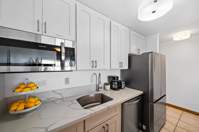 a kitchen with stainless steel appliances granite countertop a sink and a refrigerator