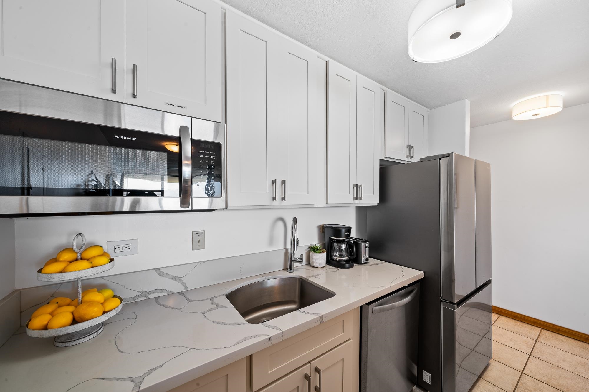 4471 Lower Honoapiilani Road, Unit 203 Lahaina, HI 96761 - Photo 9 of 40 a kitchen with stainless steel appliances granite countertop a sink and a refrigerator