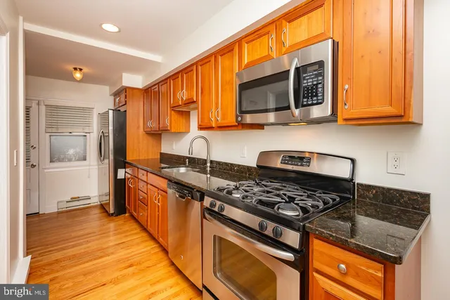 a kitchen with stainless steel appliances granite countertop a stove and a microwave