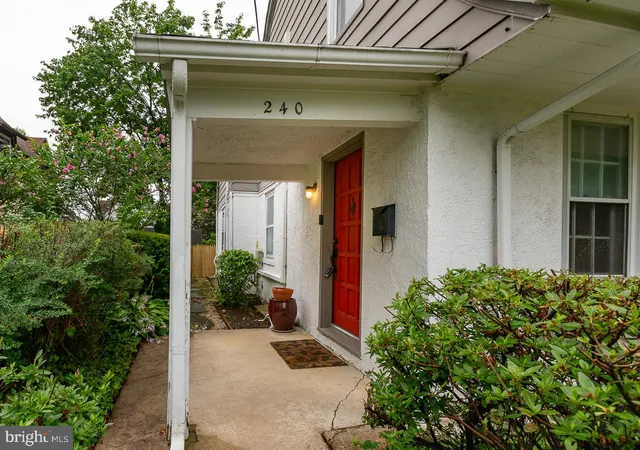a view of yellow house with potted plants