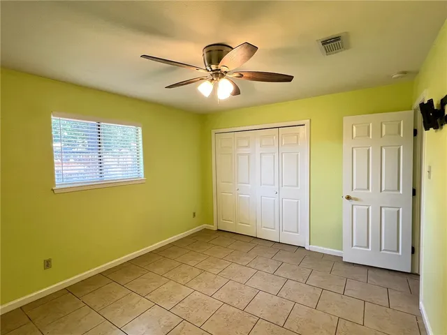 a view of an empty room with window and cabinet area