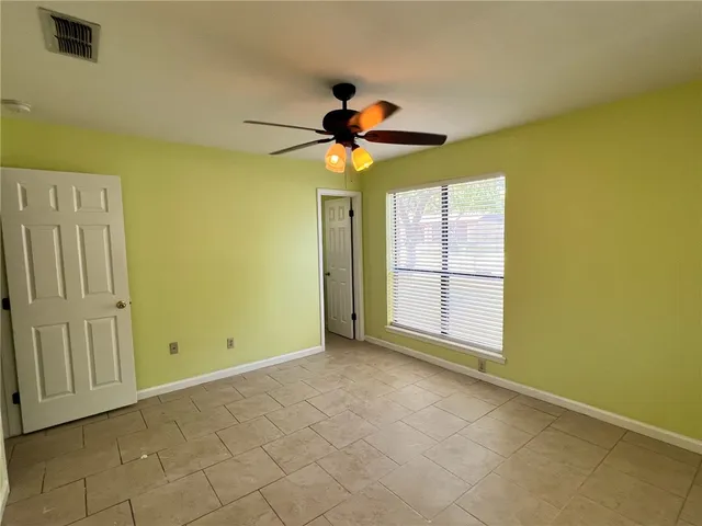 a view of a room with a chandelier fan and windows