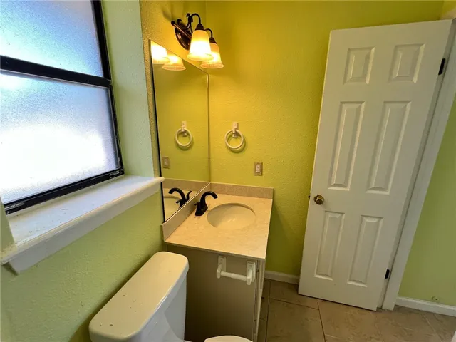 a bathroom with a sink mirror vanity and toilet
