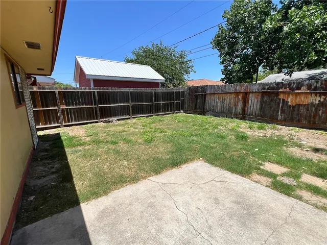 a view of a backyard with plants and a bench