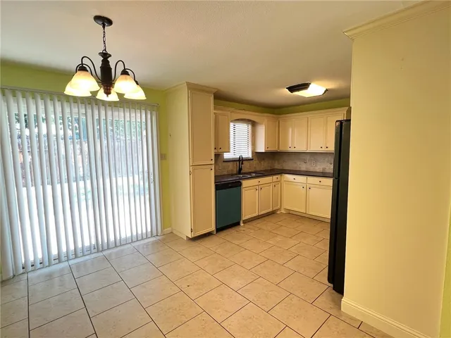 a kitchen with granite countertop a stove a sink and a refrigerator