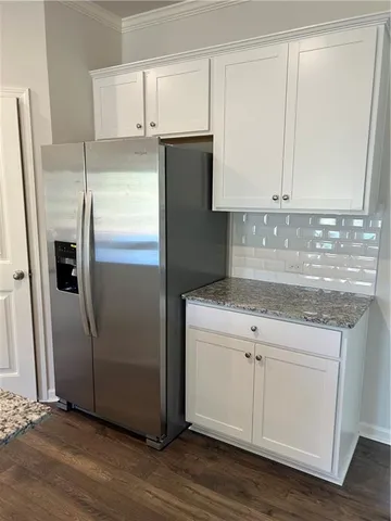 a kitchen with a refrigerator sink and cabinets