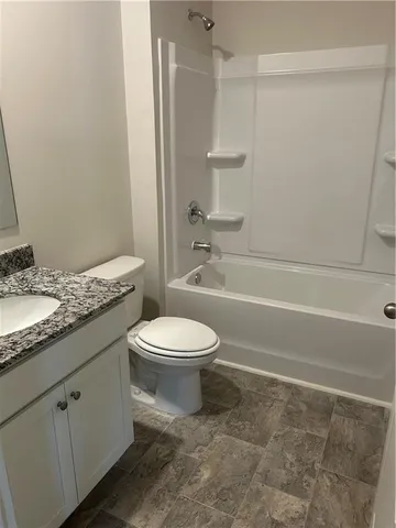 a bathroom with a granite countertop toilet a sink and a bathtub