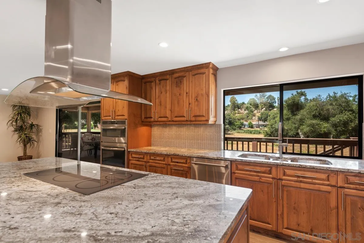 17230 Highway 67 Ramona, CA 92065 - Photo 11 of 37 a kitchen with stainless steel appliances granite countertop a stove a sink and a microwave