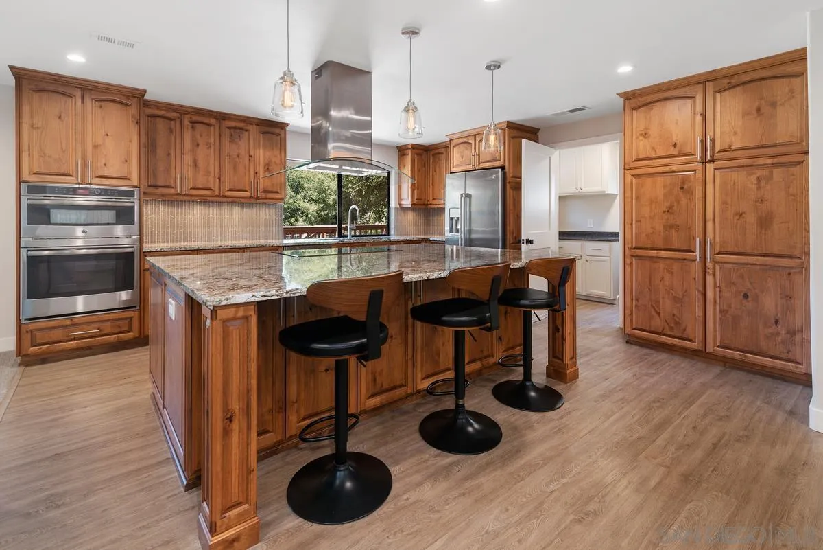 17230 Highway 67 Ramona, CA 92065 - Photo 9 of 37 a kitchen with stainless steel appliances granite countertop a sink a stove and a refrigerator