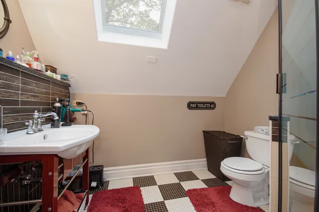 a bathroom with a sink a toilet and a mirror