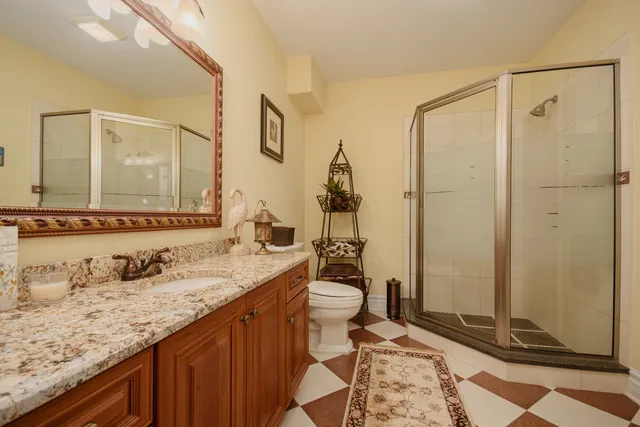 a bathroom with a granite countertop sink toilet and shower